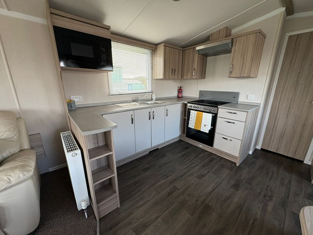 Modern equipped kitchen with gas cooker and white cabinets - full facilities in Sands of Luce holiday home