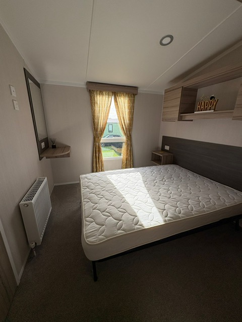 Cozy bedroom in static caravan with light and natural warmth - restful sleeping quarters at holiday park