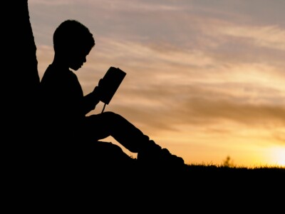boy reading book at sunset