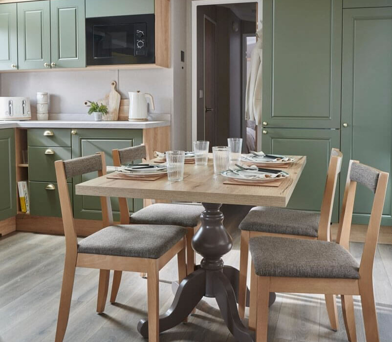Elegant dining table with fitted kitchen in luxury caravan - sophisticated interior design Swift Provence